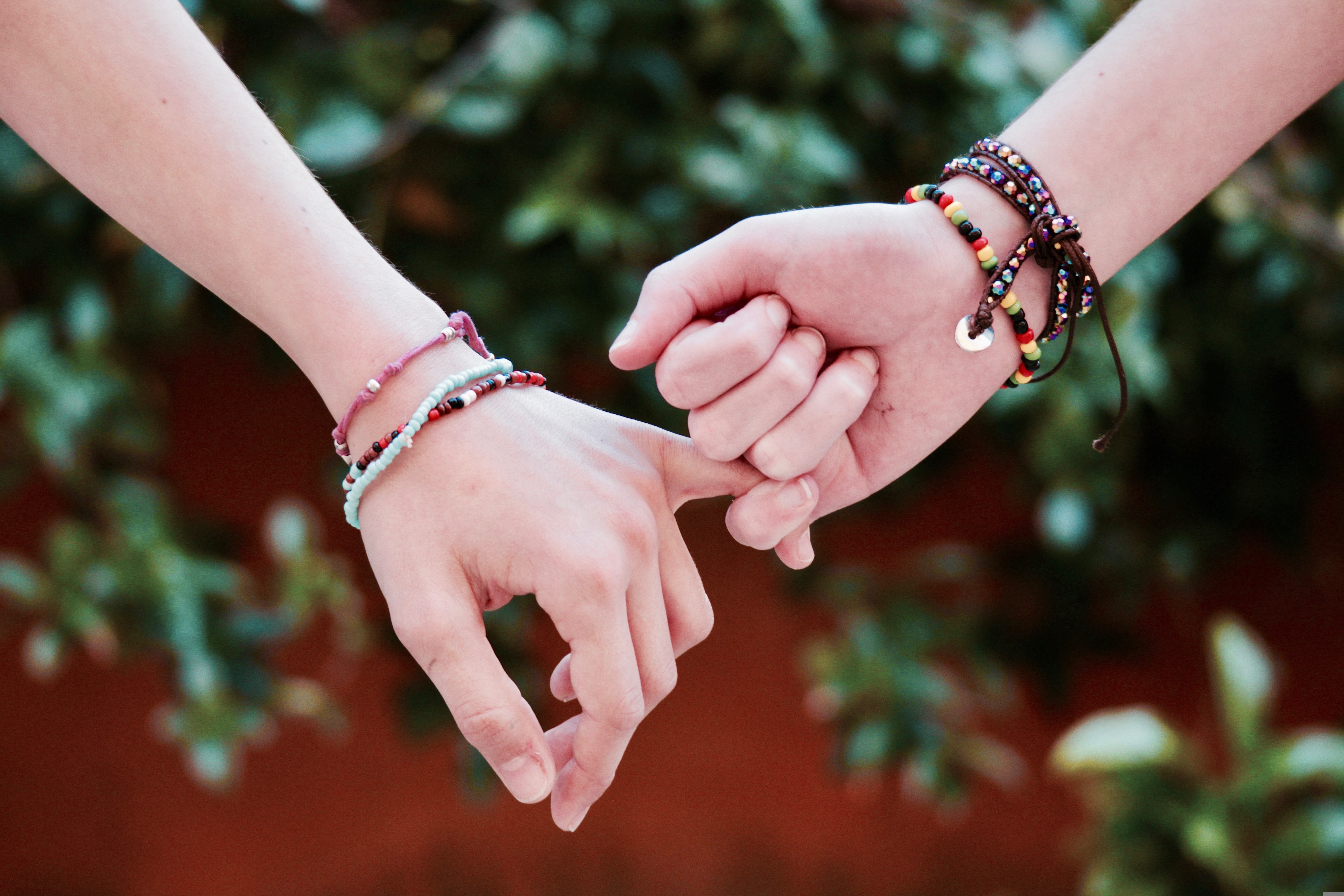 braclets on wrist of two people holding hands